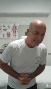 גבר מחזיק את כף היד עם כאב, ברקע כתף וגב מודגשים – המחשה לקשר בין כאב ביד לכאב בגב